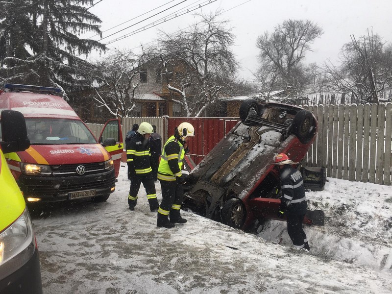 FOTO/VIDEO – HERINA: Două persoane blocate într-o mașină ce s-a înfipt în șanțul de pe marginea drumului